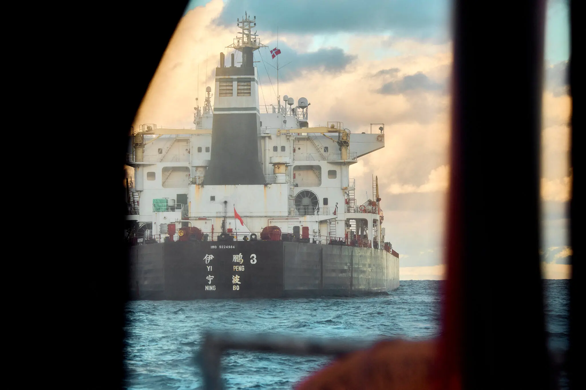 Корабель Yi Peng 3 під китайським прапором стояв на якорі, і за ним стежив патрульний корабель ВМС Данії поблизу Ютландії, Данія, у листопаді.